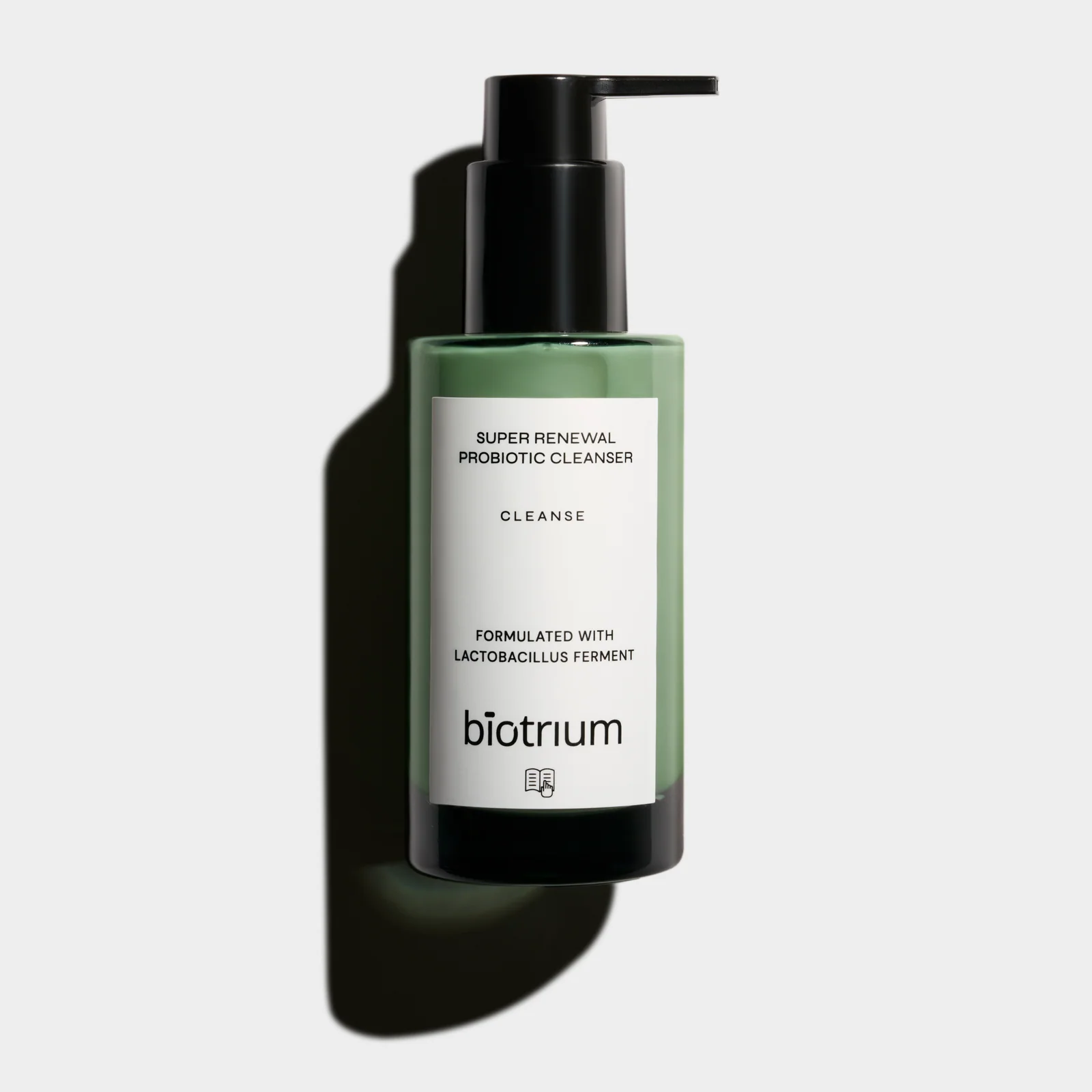 Front view of a green Biotrium Super Renewal cleanser bottle with a black pump and a defined shadow on a light background.