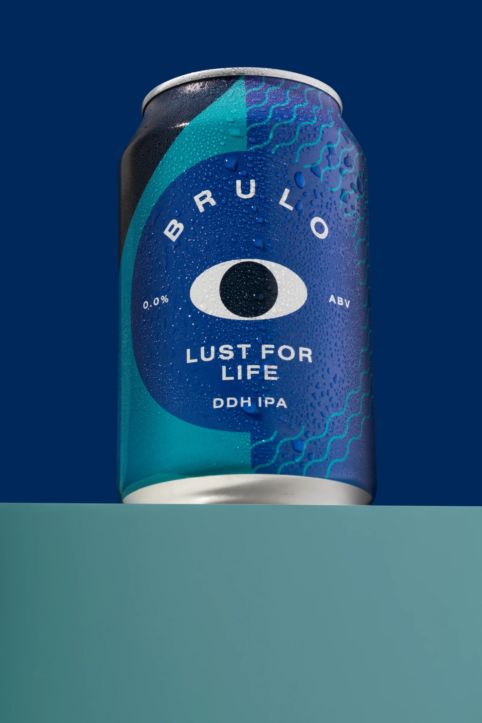 Close-up of a blue Brülo Lust for Life can covered in condensation above a teal platform.