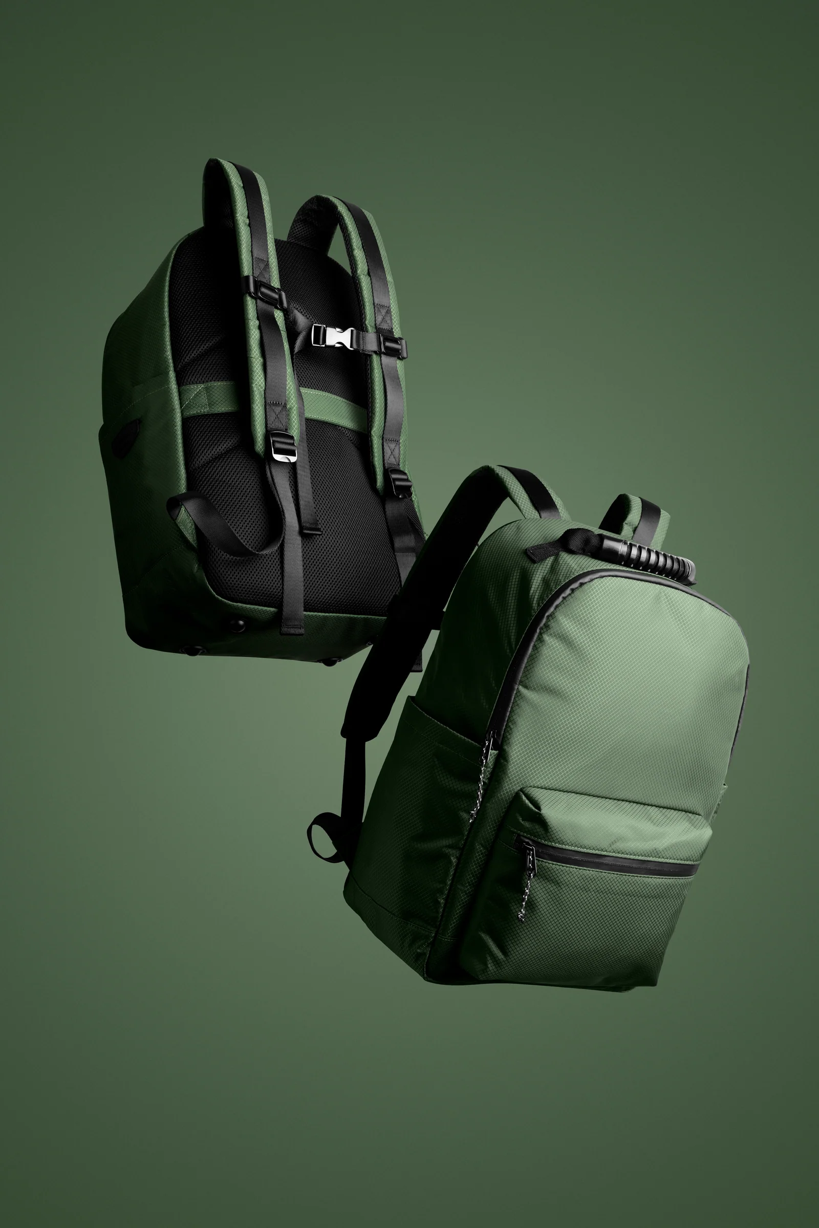 Front and rear views of a green Double Oak backpack suspended against green.