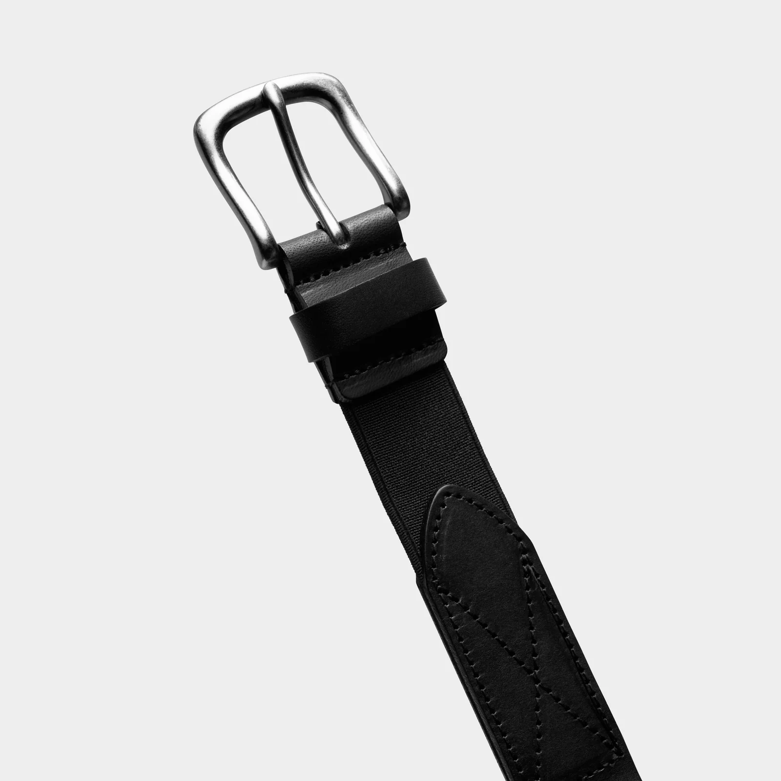 Close-up of a black Double Oak belt showing its silver-coloured buckle and stitched attachment.