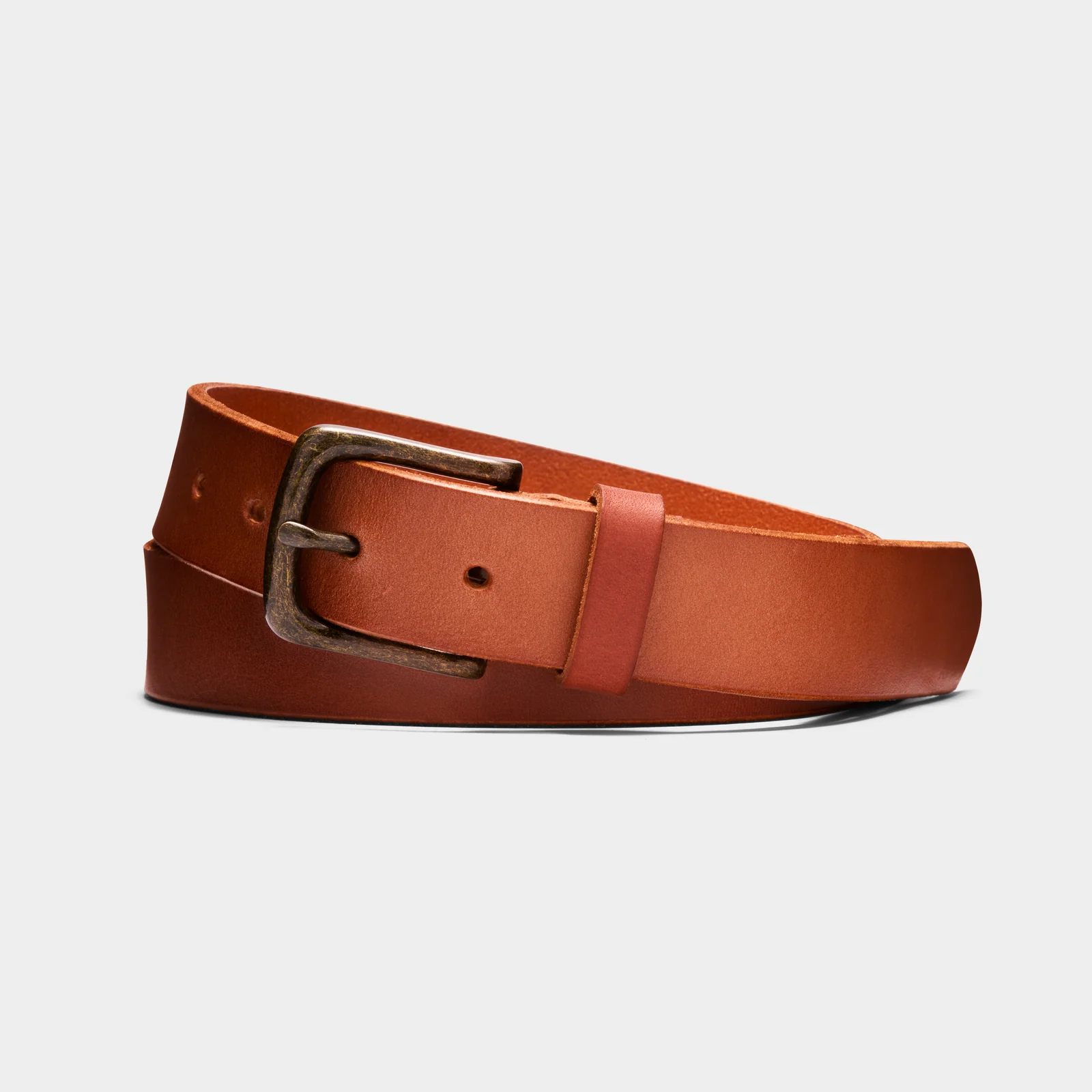 Brown Double Oak leather belt with a bronze-coloured buckle, loosely coiled on a light background.