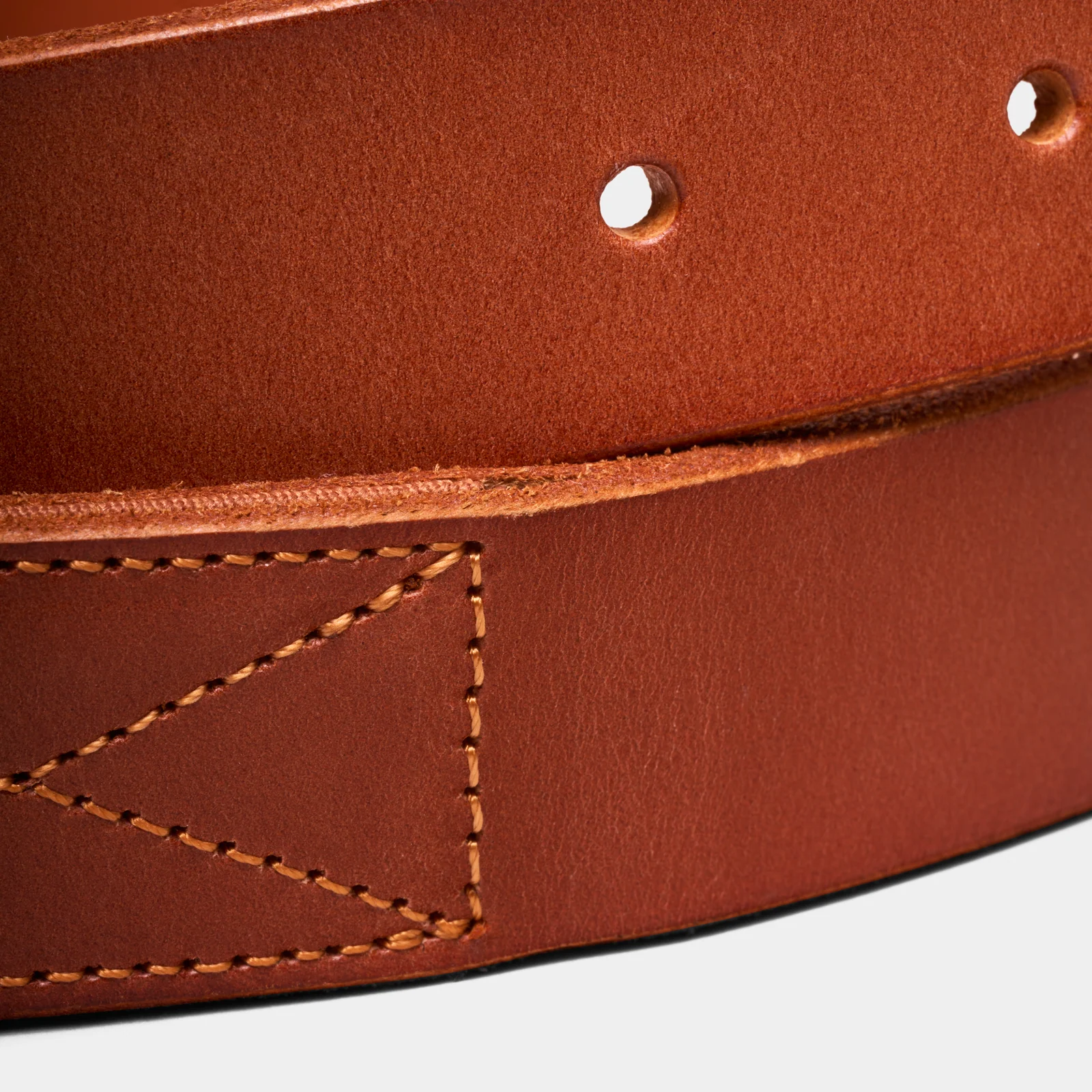 Close-up of brown Double Oak belt leather showing stitching and adjustment holes.