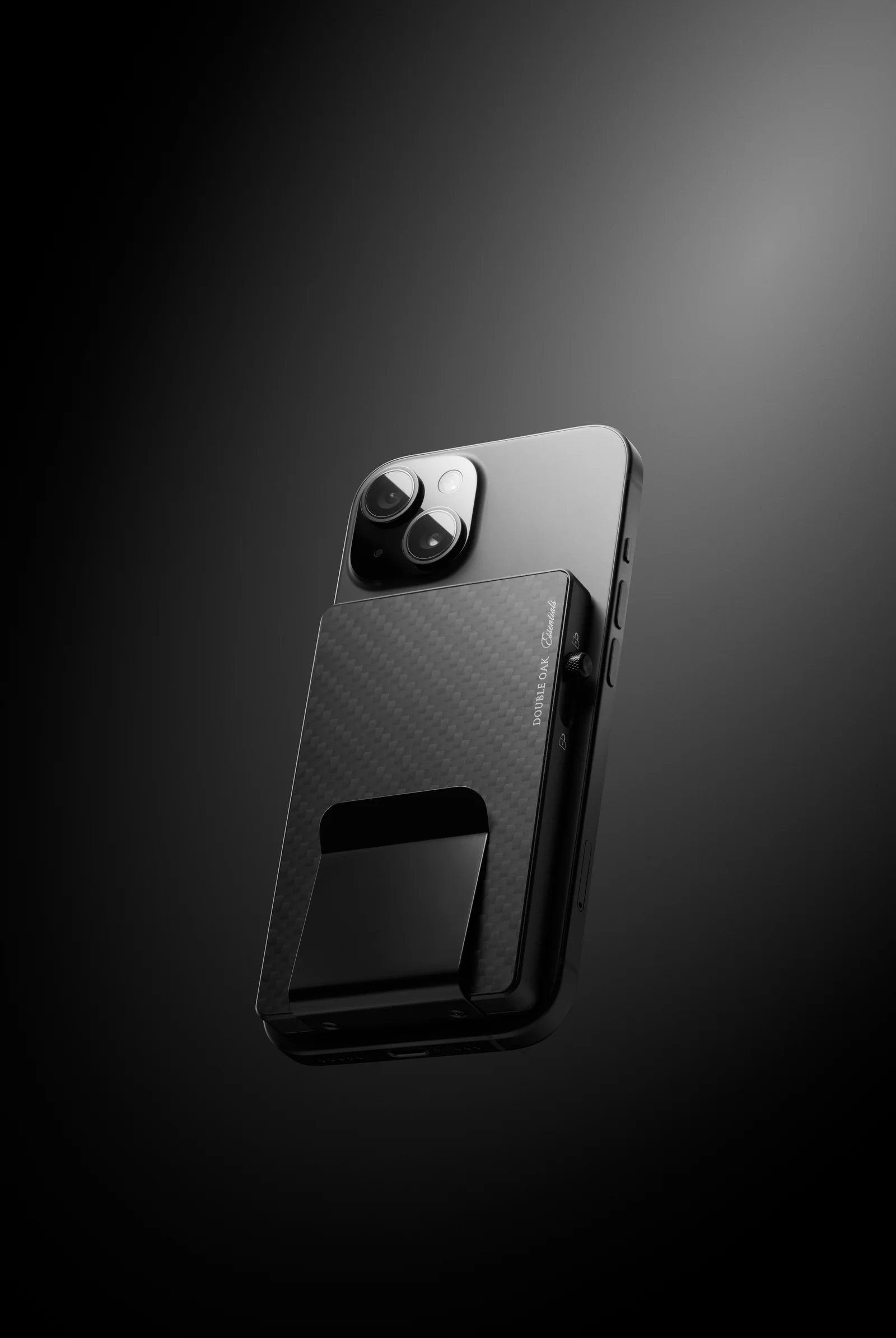 Black patterned Double Oak cardholder attached to the back of a phone against a dark background.