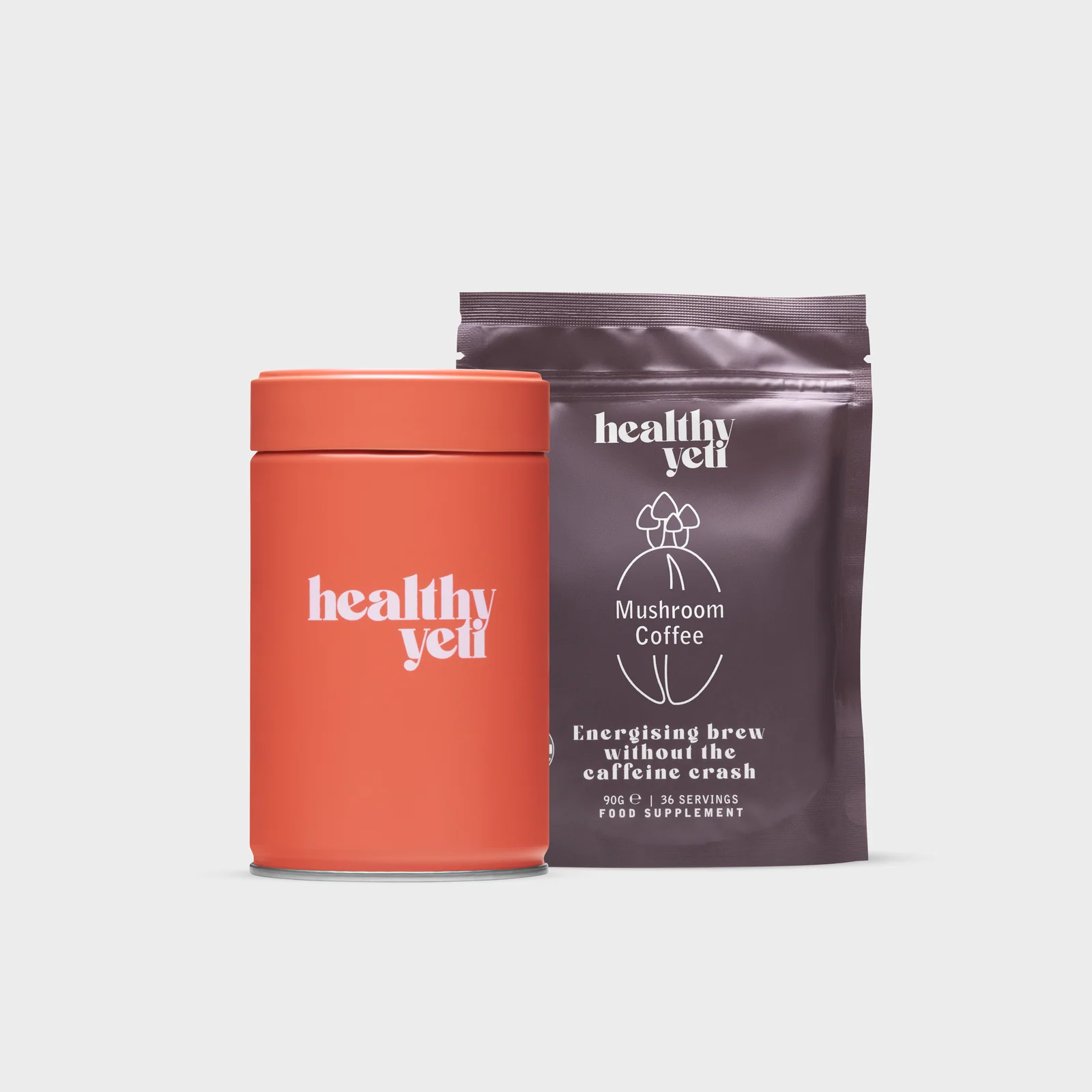 Orange Healthy Yeti tin beside a brown Mushroom Coffee pouch on a light background.