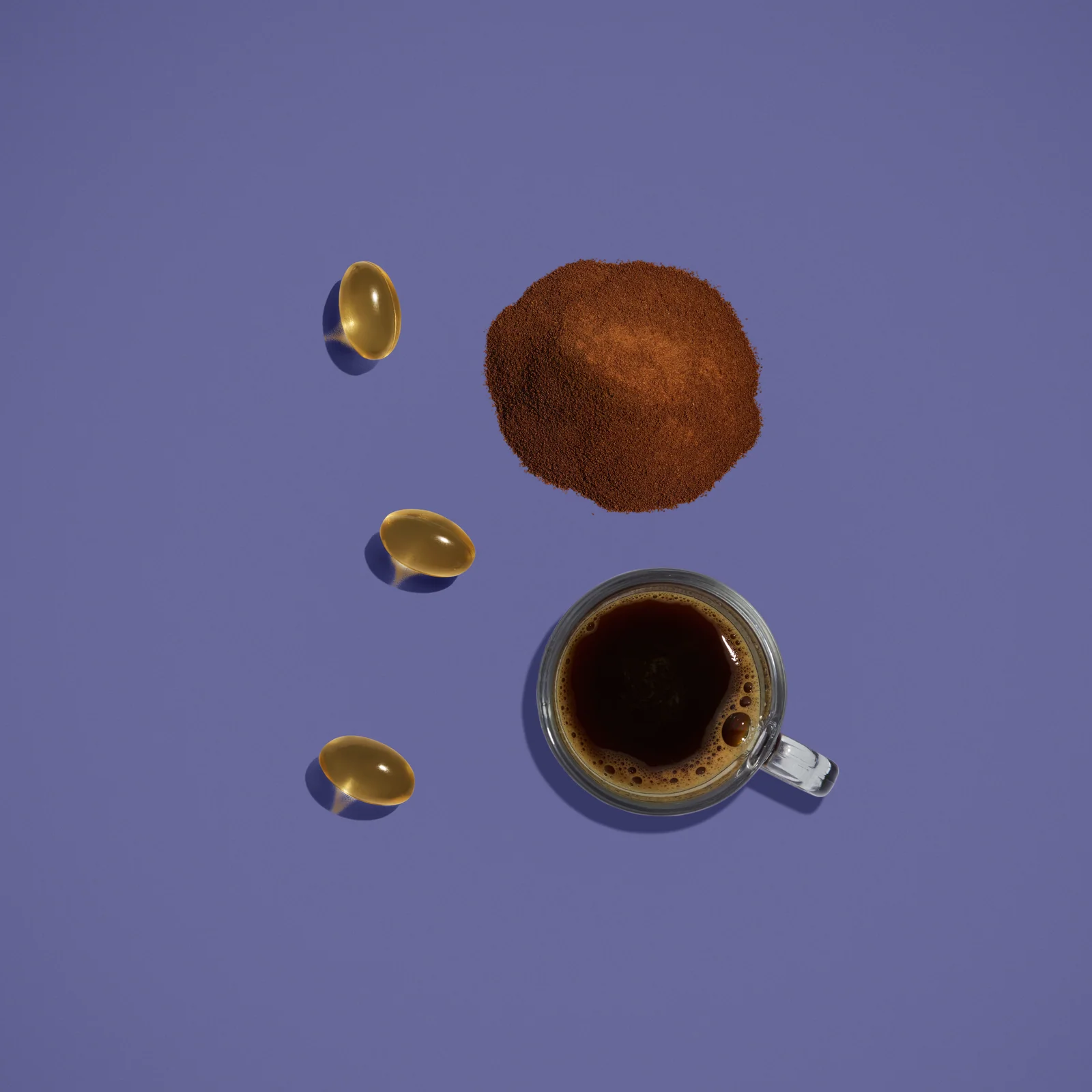 Overhead view of black coffee, brown powder and three golden capsules against lilac.