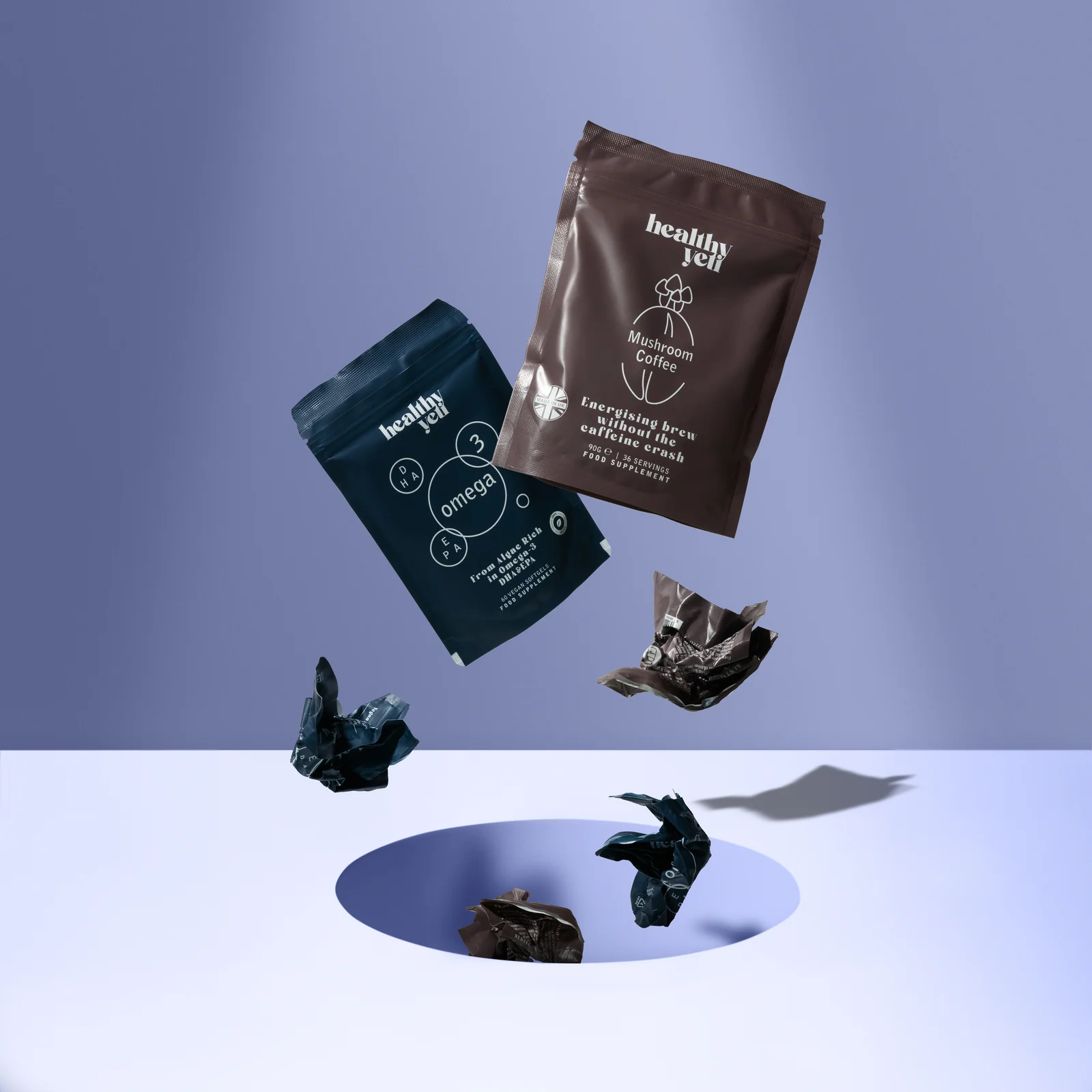 Healthy Yeti pouches suspended above crumpled packaging and a circular opening on a lilac set.