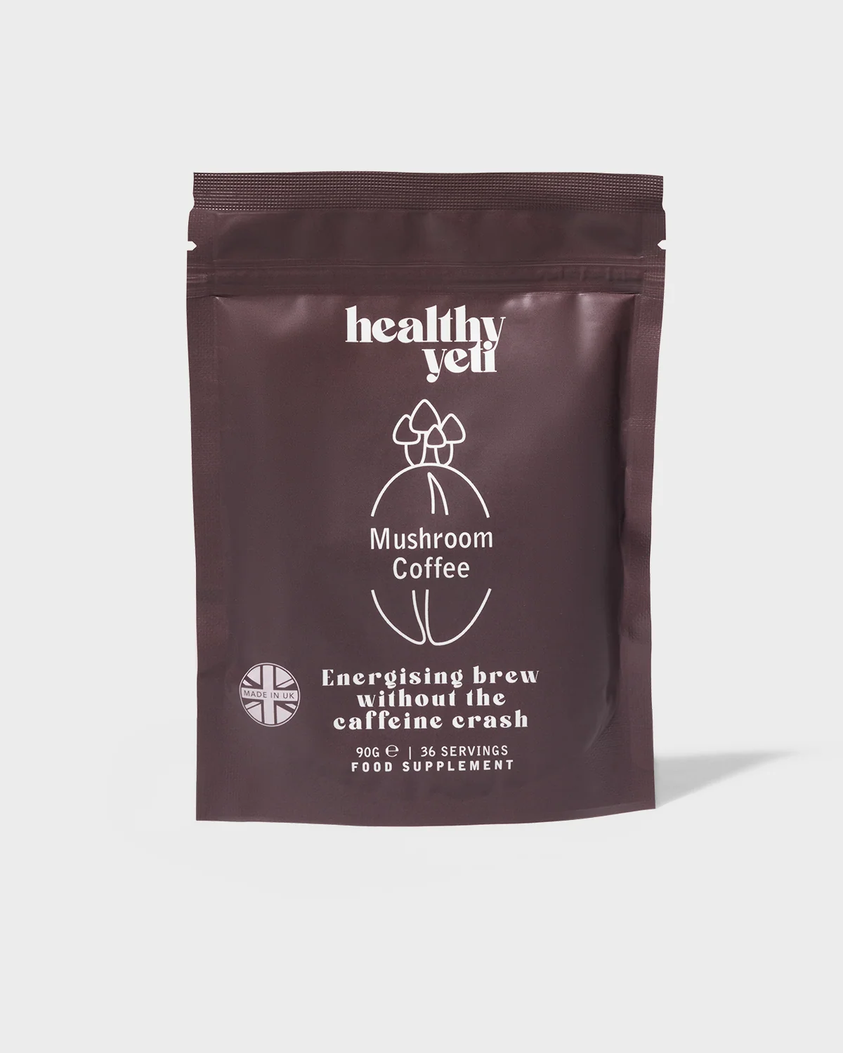 Front view of a brown Healthy Yeti Mushroom Coffee pouch with a defined shadow on a light background.