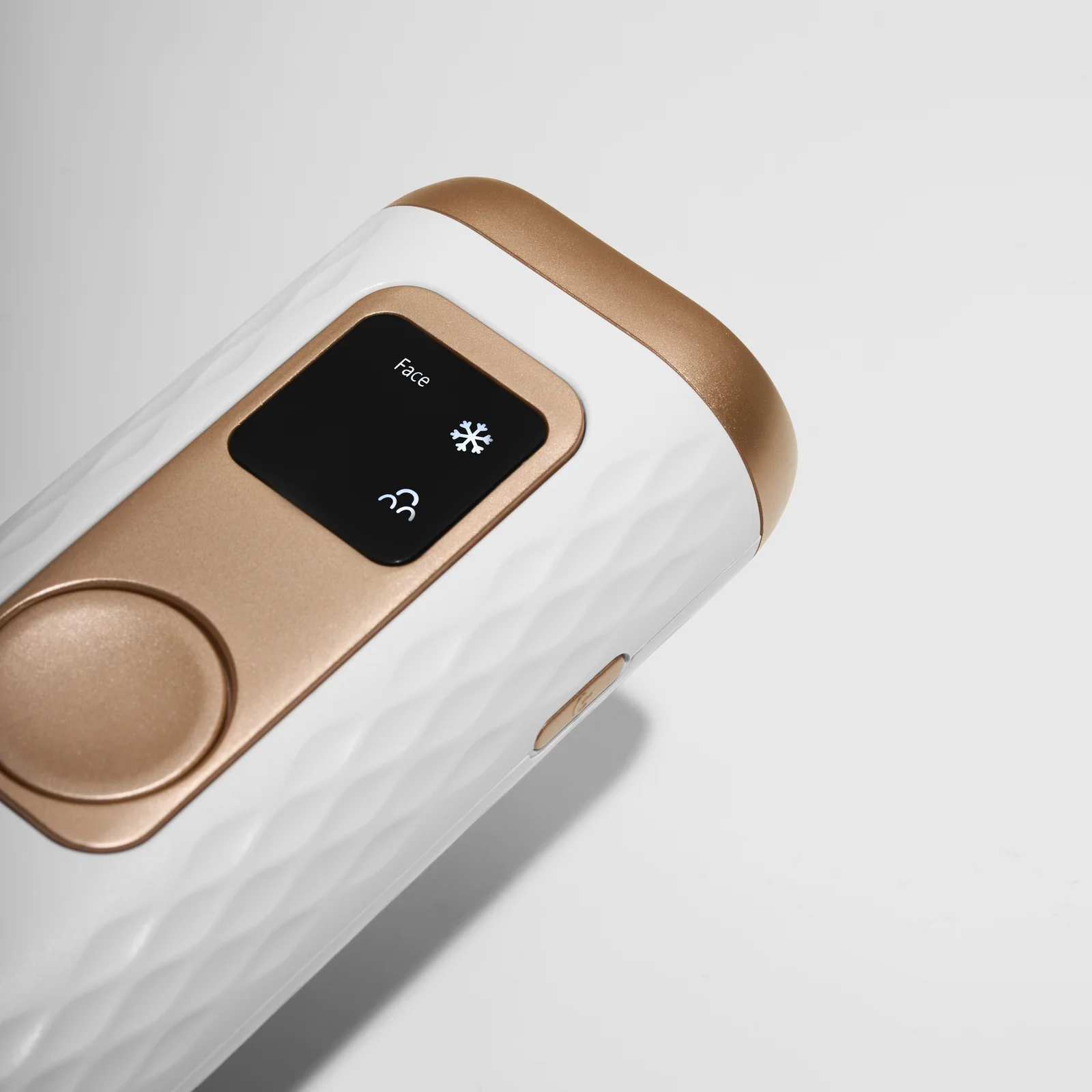 Angled close-up of the Keskine IPL device screen and gold control button.