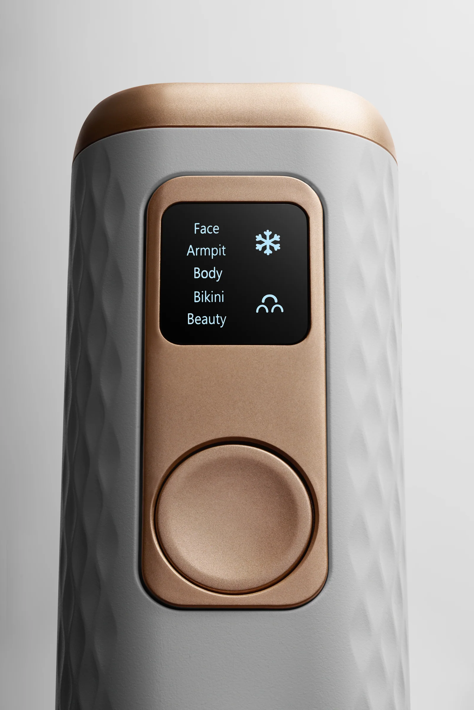 Front close-up of the Keskine IPL device showing its illuminated screen and gold control button.