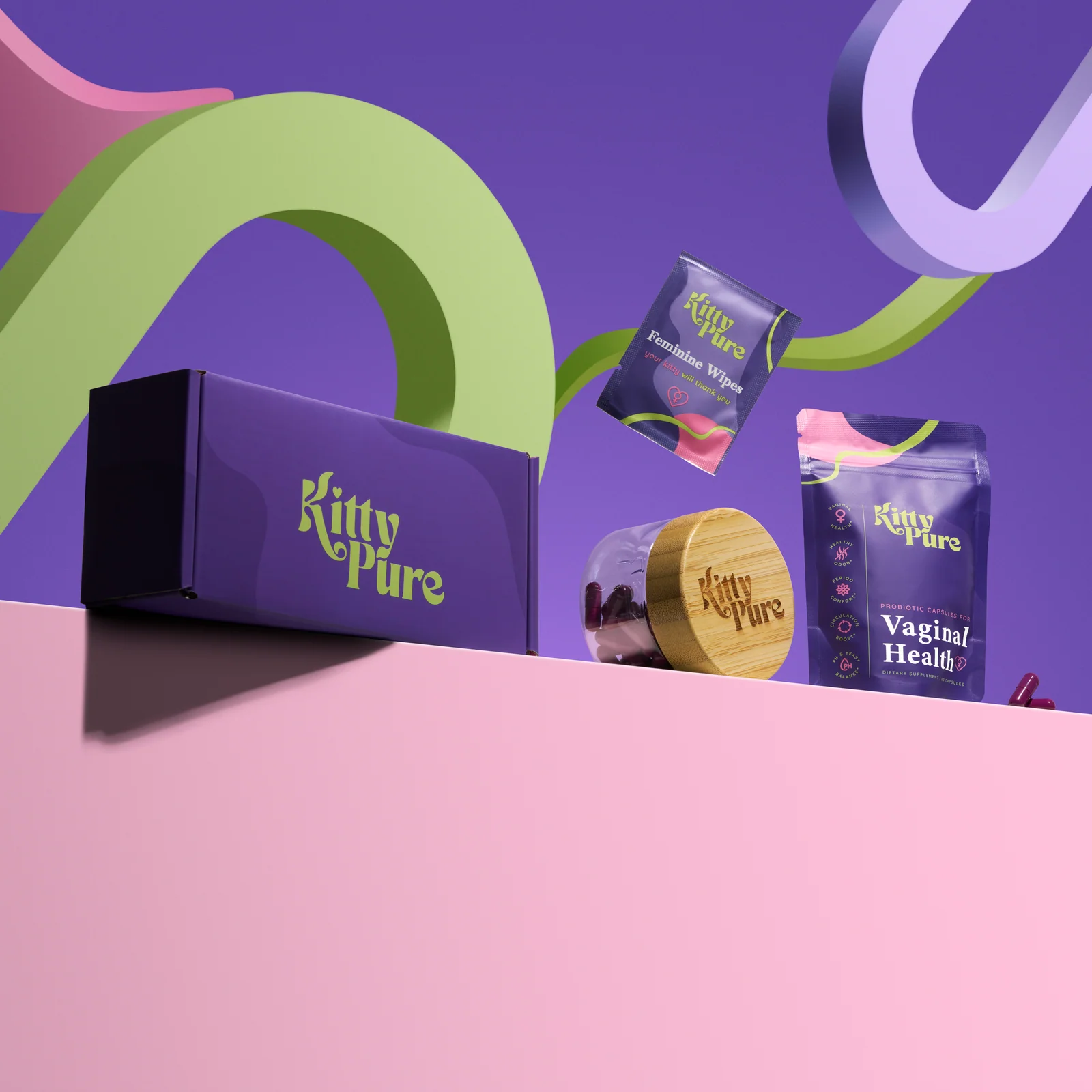 KittyPure box, supplement jar, pouch and wipes sachet arranged with colourful curved props against purple and pink.
