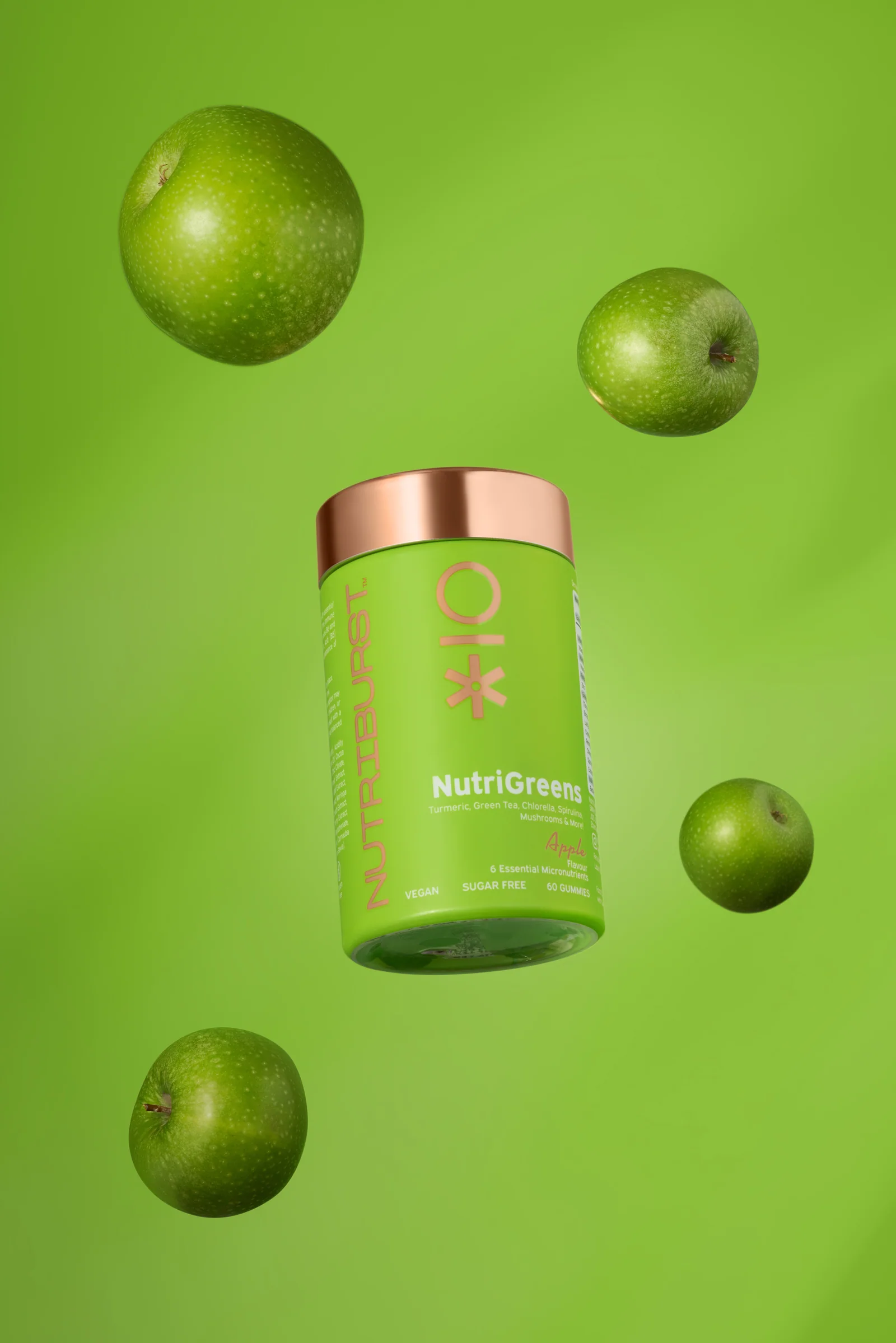 Lime-green Nutriburst NutriGreens jar surrounded by floating green apples against green.