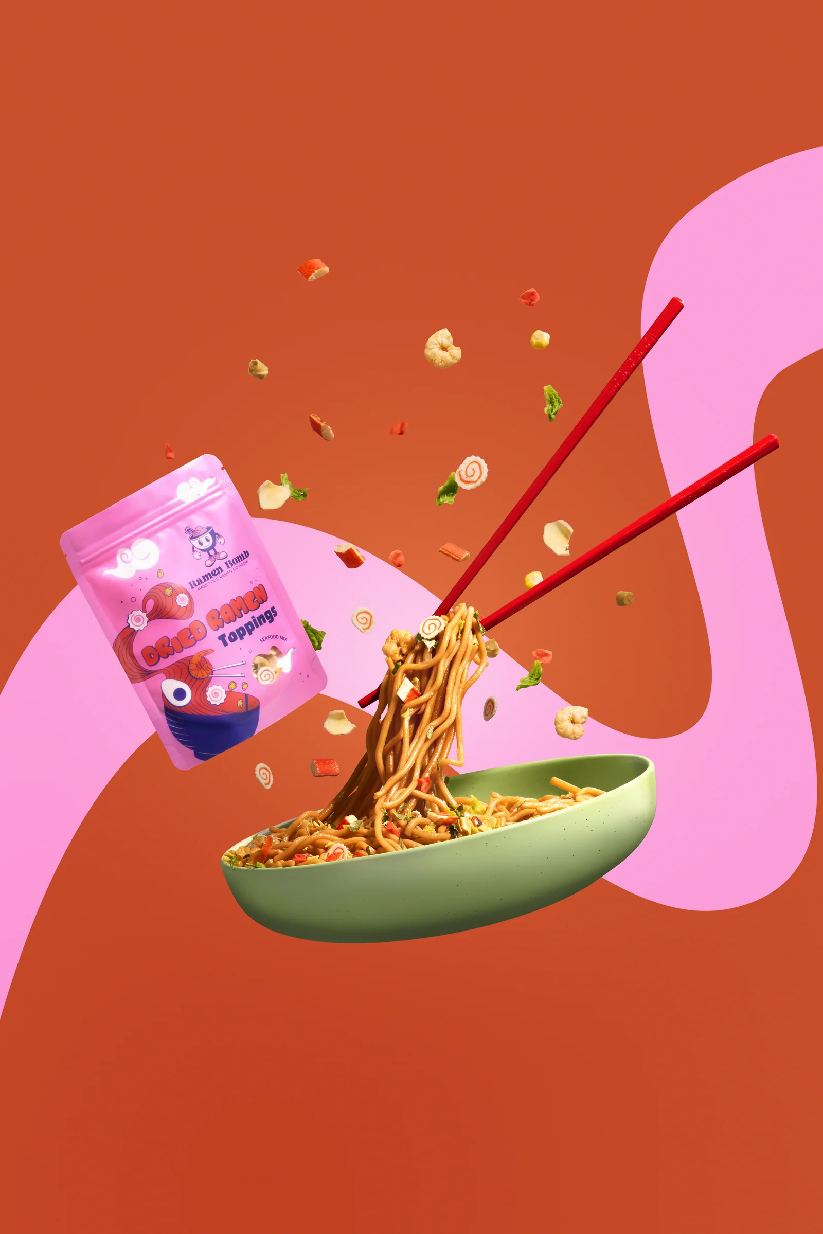 Ramen Bomb packet, chopsticks and a green bowl of lifted noodles with floating toppings against orange and pink.