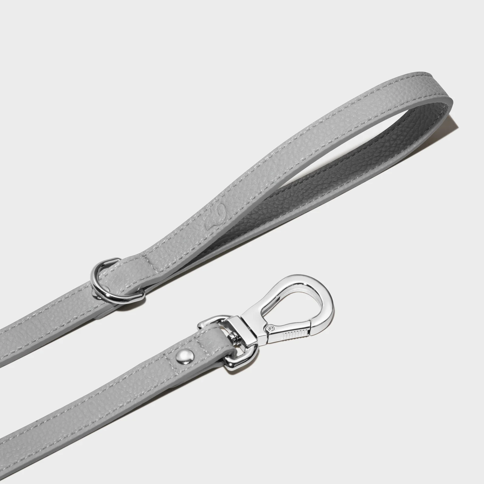 Grey Truffle and Paw leather lead showing its loop handle and silver-coloured clasp on a light background.