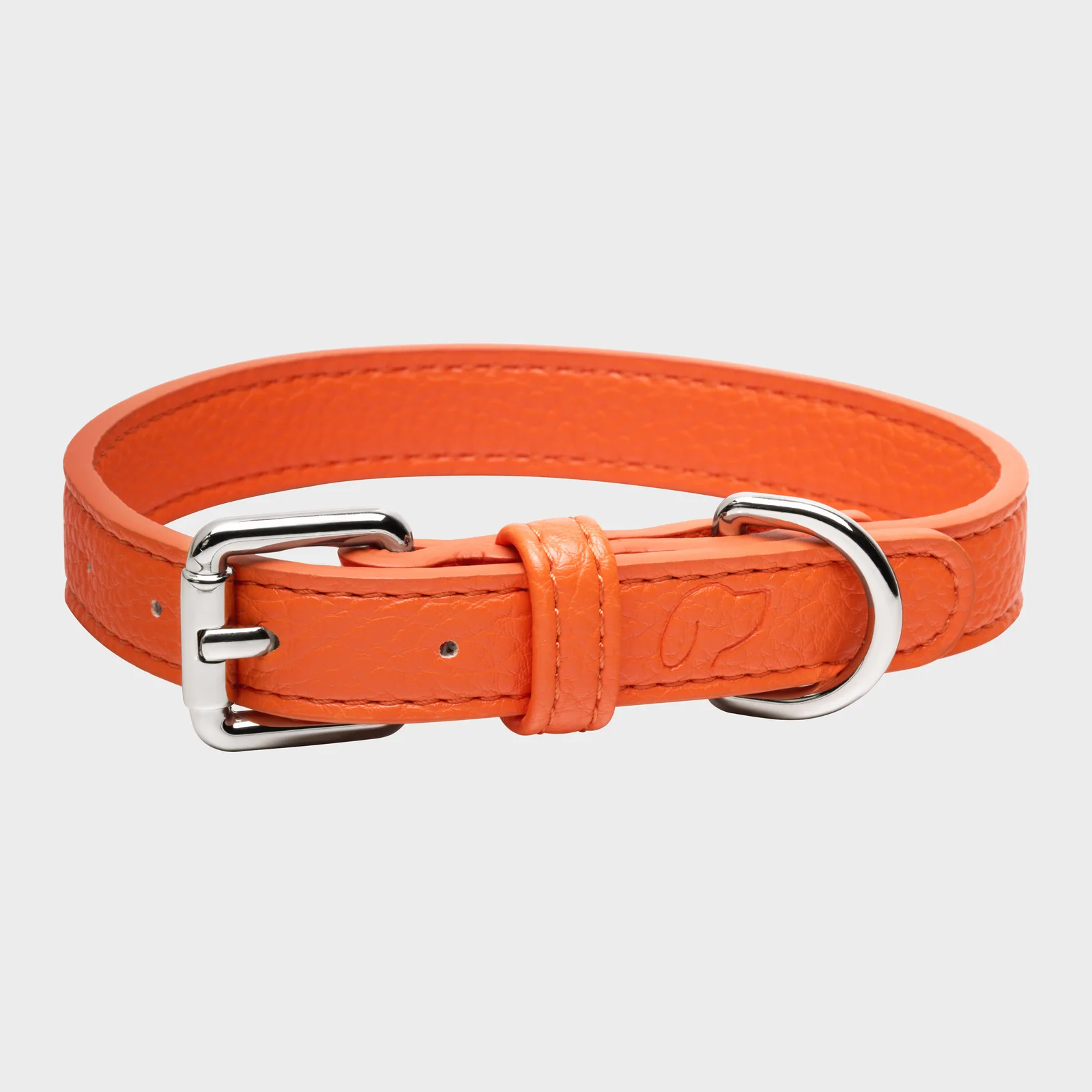 Orange Truffle and Paw leather collar with a silver-coloured buckle and ring on a light background.