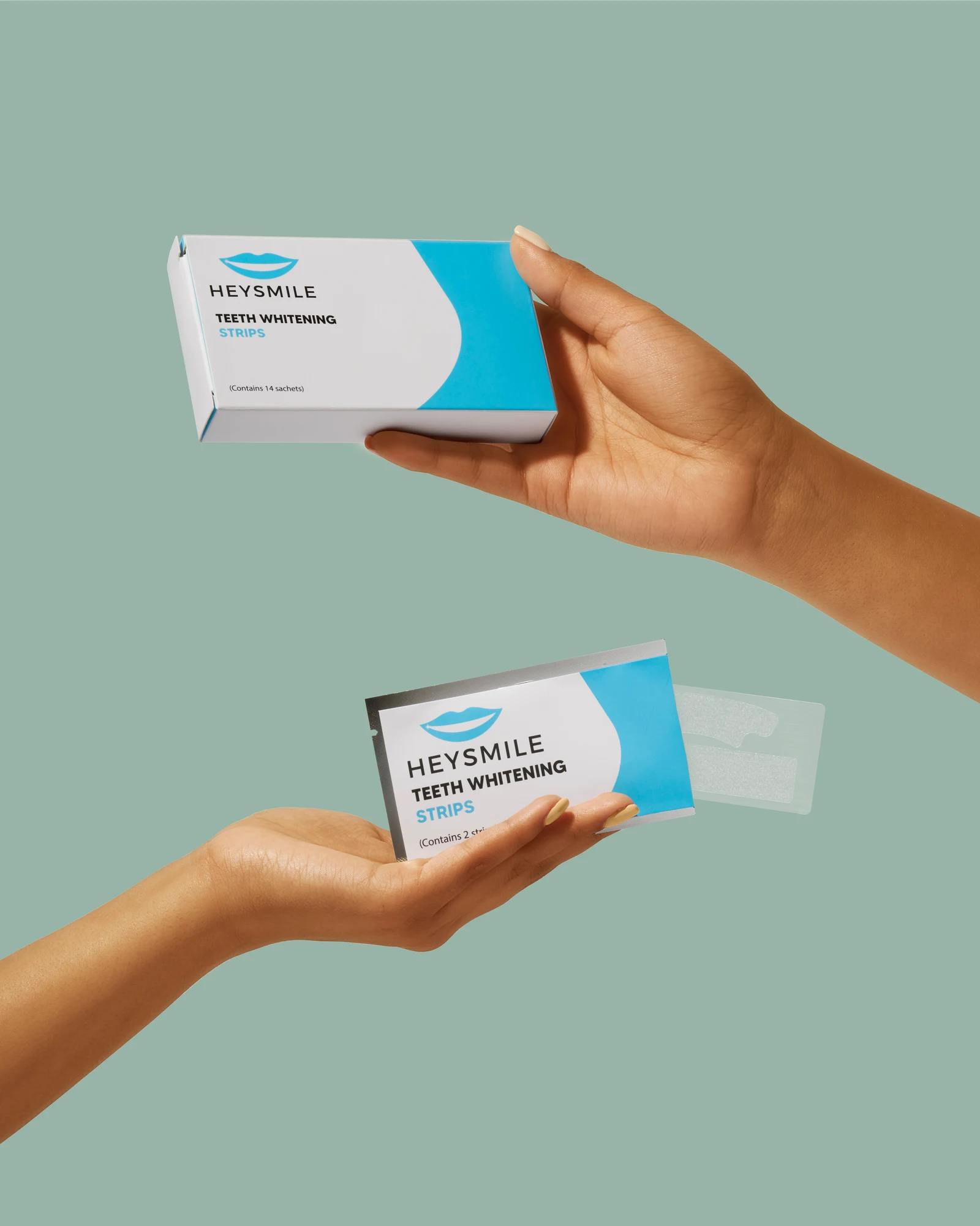Two hands holding a Hey Smile teeth-whitening box and sachet against a muted green background.