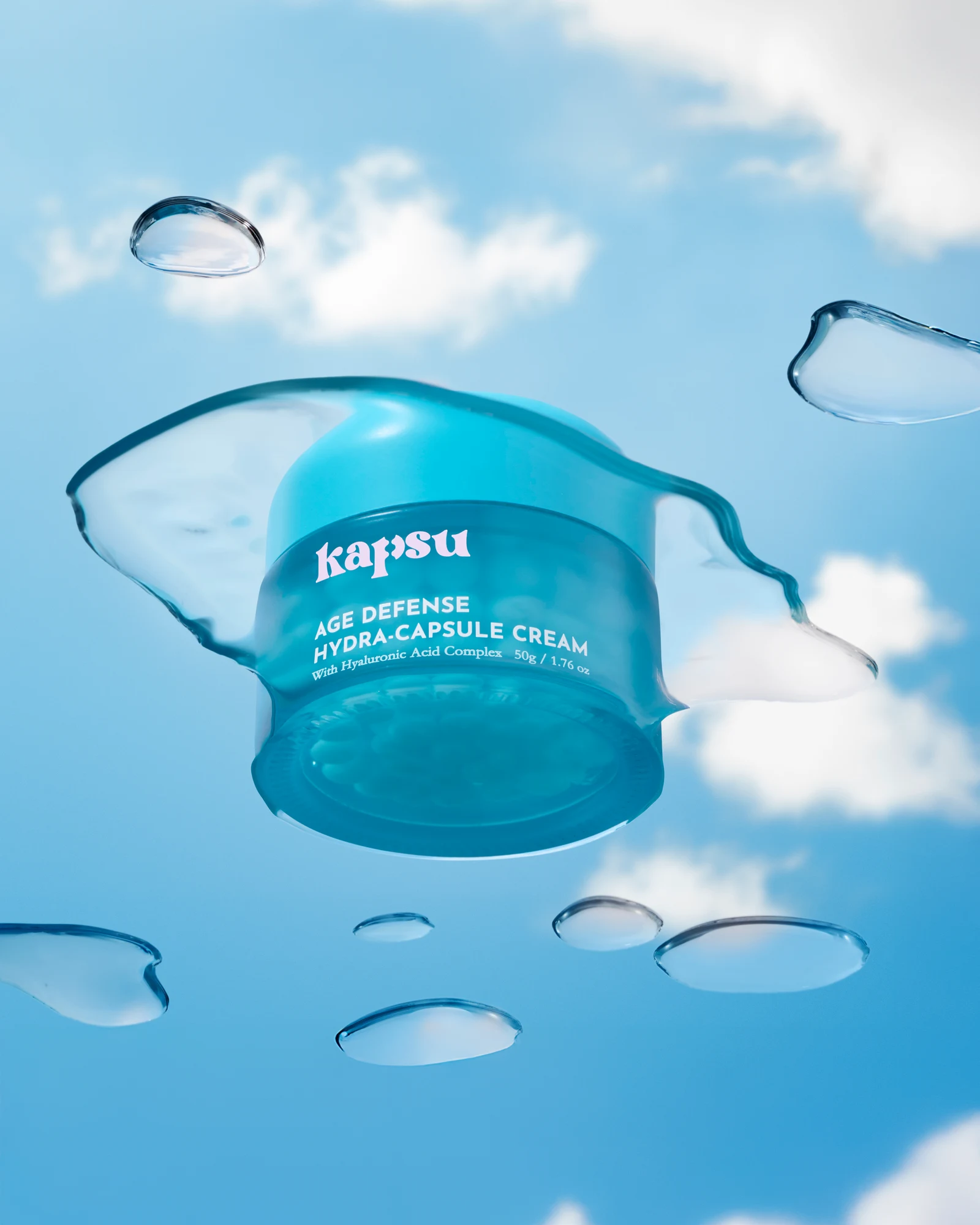 Turquoise Kapsu skincare jar suspended among clear gel droplets against a blue sky.