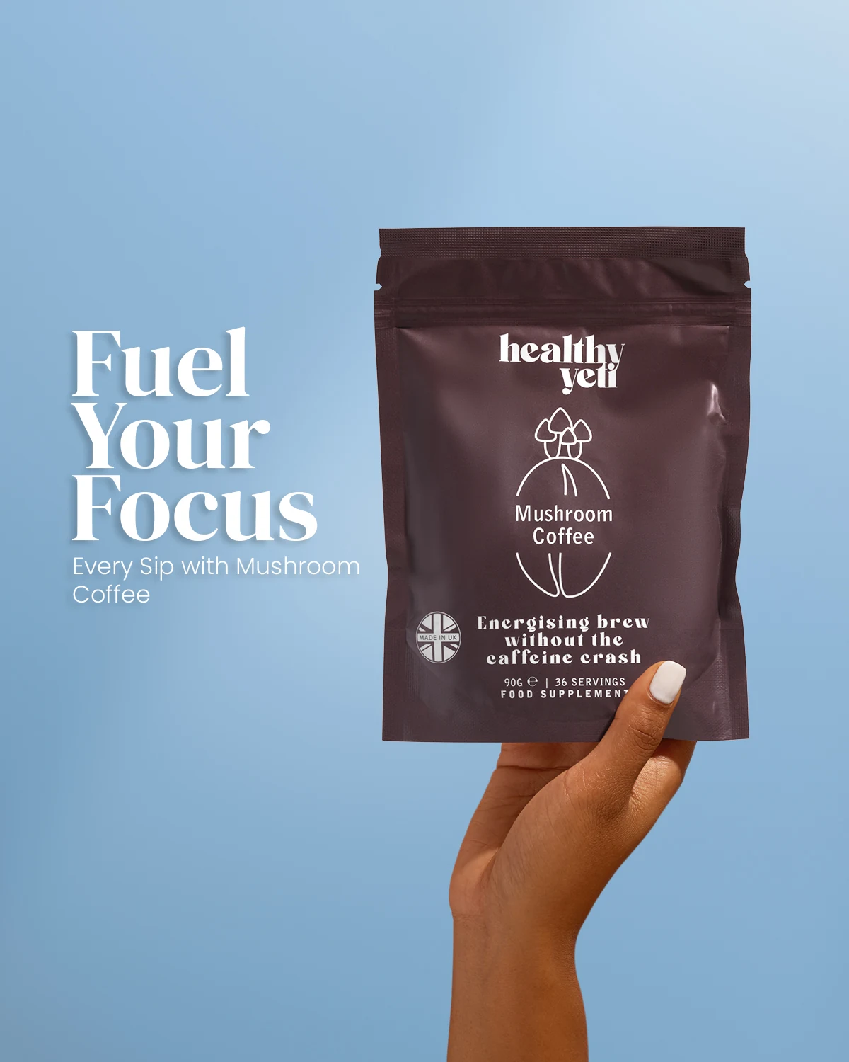Hand holding a brown Healthy Yeti Mushroom Coffee pouch against blue, with the headline “Fuel Your Focus”.