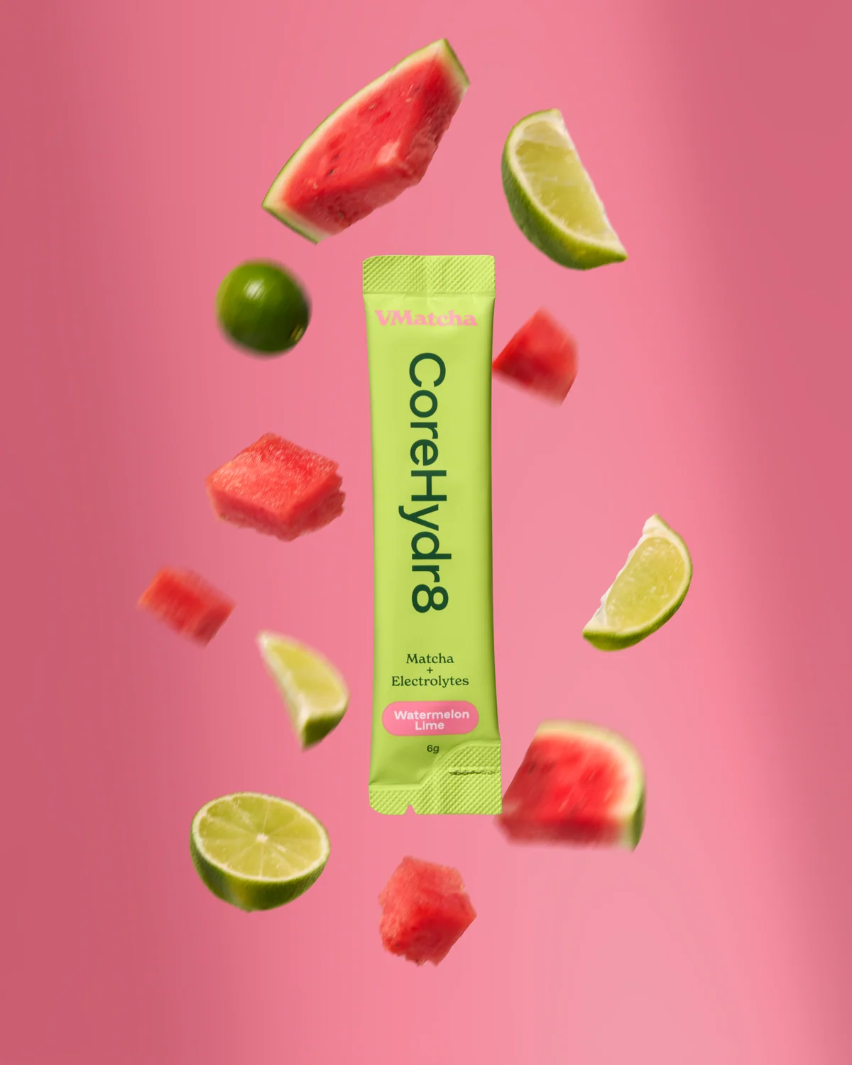 Green VMatcha CoreHydr8 sachet surrounded by watermelon pieces and lime wedges against pink.